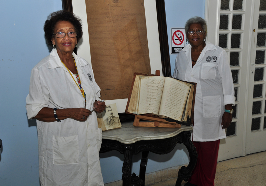 Las especialistas Inés Baró Valle y María Elena Rodríguez junto a su labor restaurada y el libro de protocolo